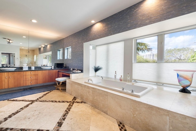 full bathroom with double vanity, recessed lighting, a sink, and a garden tub