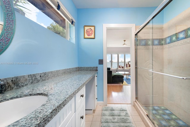 ensuite bathroom featuring vanity, a shower stall, tile patterned floors, and connected bathroom