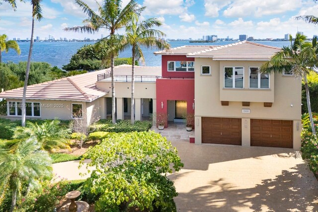 1500 NE 103rd St, Miami Shores, FL 33138 - view of front of property with an attached garage, stucco siding, driveway, a balcony, and a tile roof