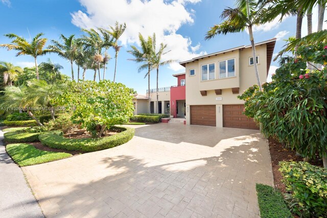 mediterranean / spanish-style home with decorative driveway, a garage, and stucco siding