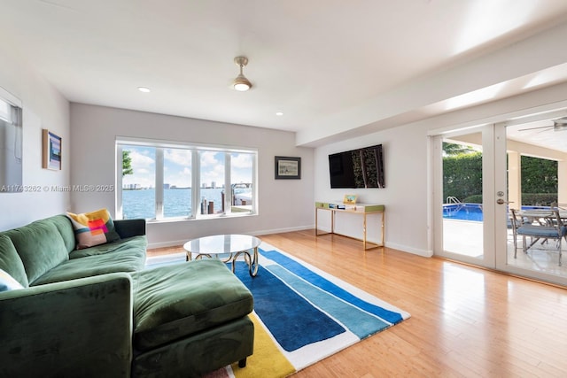 living area with baseboards, plenty of natural light, and wood finished floors