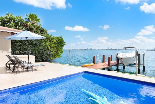 outdoor pool featuring boat lift, a boat dock, a water view, and a patio area