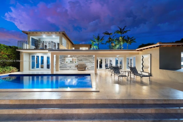 1500 NE 103rd St, Miami Shores, FL 33138 - back of property featuring a balcony, a patio area, stucco siding, an outdoor pool, and french doors