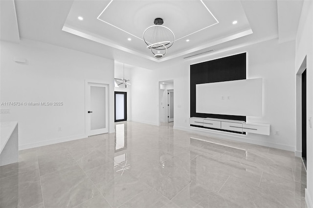 spare room featuring a towering ceiling, a notable chandelier, and a tray ceiling