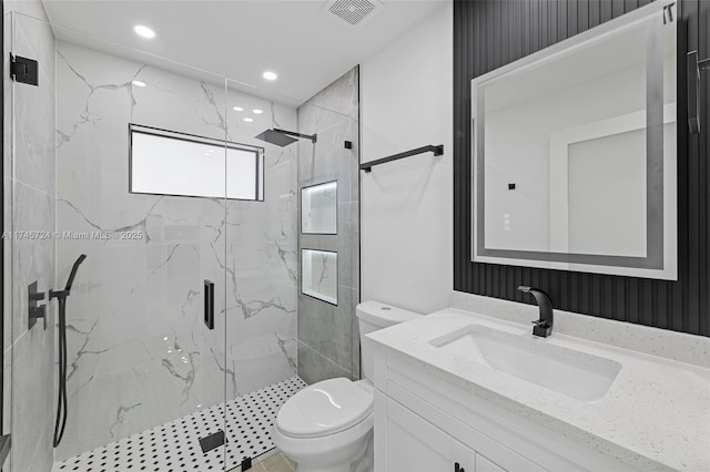 bathroom with vanity, a shower with shower door, and toilet