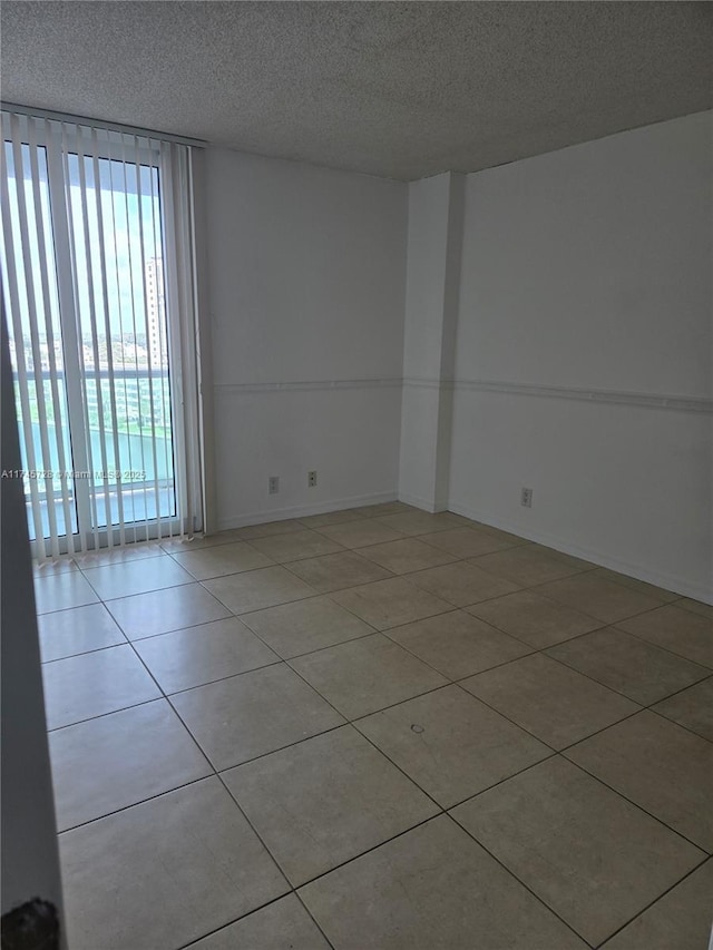 tiled empty room with a textured ceiling