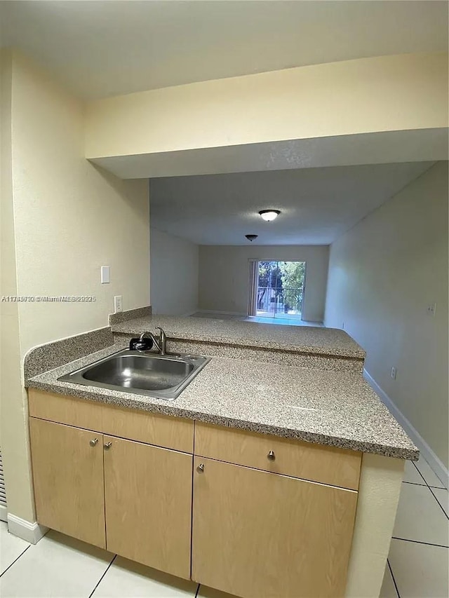 kitchen featuring sink, light tile patterned floors, and light brown cabinetry