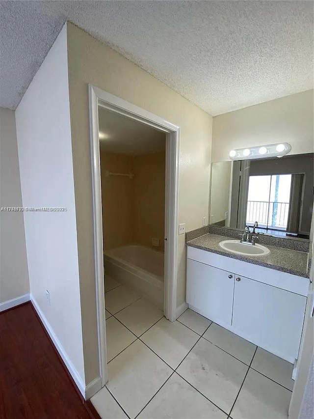 bathroom with vanity, tile patterned flooring, and a textured ceiling