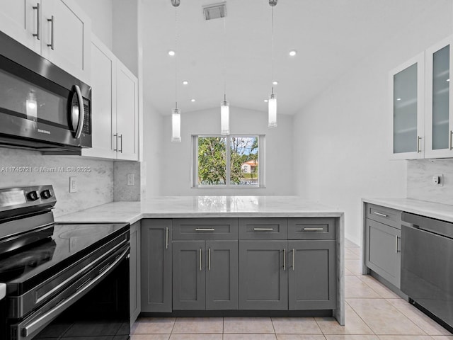 kitchen with gray cabinetry, white cabinetry, pendant lighting, stainless steel appliances, and light stone countertops