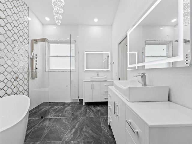 bathroom with vanity and shower with separate bathtub