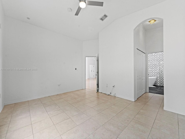 spare room with ceiling fan, light tile patterned floors, and high vaulted ceiling