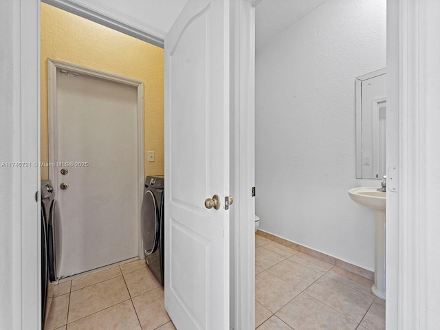 bathroom featuring washer / clothes dryer, sink, tile patterned flooring, and toilet