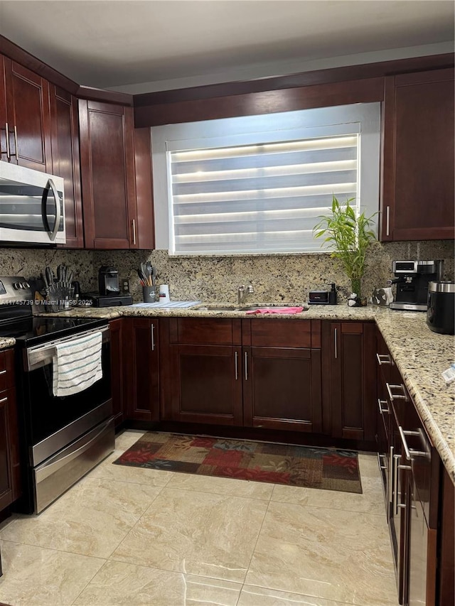 kitchen featuring appliances with stainless steel finishes, sink, backsplash, and light stone counters