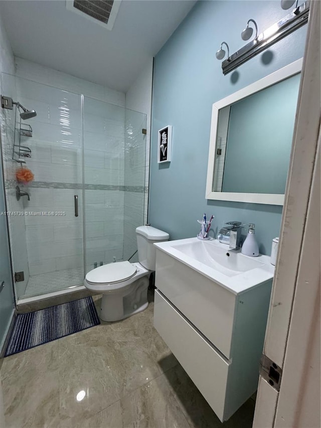 bathroom with vanity, toilet, and a shower with door