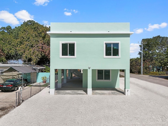 back of property featuring stairway, driveway, and a carport
