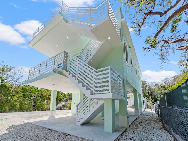 exterior space with fence, a patio area, and stairway