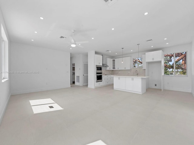 unfurnished living room featuring recessed lighting, visible vents, a ceiling fan, and baseboards