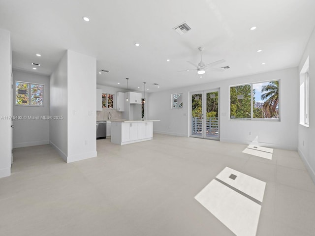 unfurnished living room with visible vents, a ceiling fan, baseboards, and recessed lighting