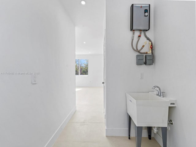 bathroom featuring baseboards, recessed lighting, and a sink