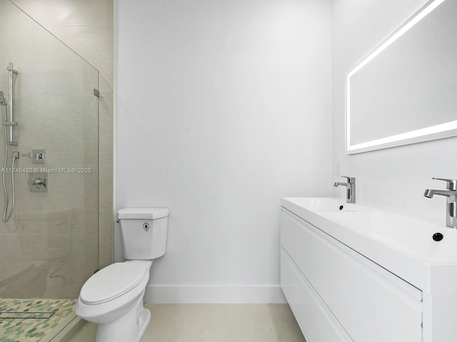 bathroom featuring baseboards, vanity, a shower stall, and toilet