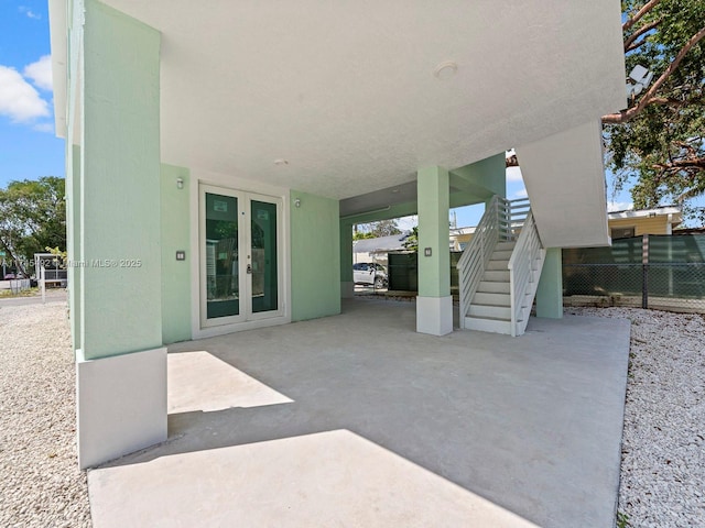 view of patio / terrace featuring french doors, stairs, and fence