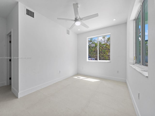 spare room with baseboards, visible vents, and ceiling fan
