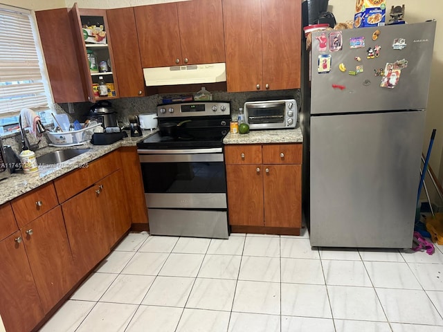 kitchen featuring sink, appliances with stainless steel finishes, tasteful backsplash, and light stone countertops