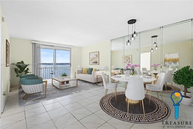 dining space featuring light tile patterned floors and a water view