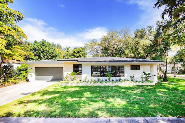 ranch-style home featuring a garage, concrete driveway, a front yard, and stucco siding