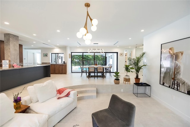 living room with baseboards, an inviting chandelier, and recessed lighting