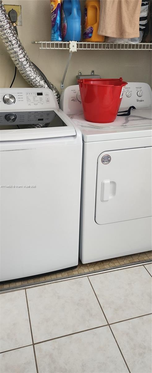 laundry area with laundry area, independent washer and dryer, and tile patterned floors