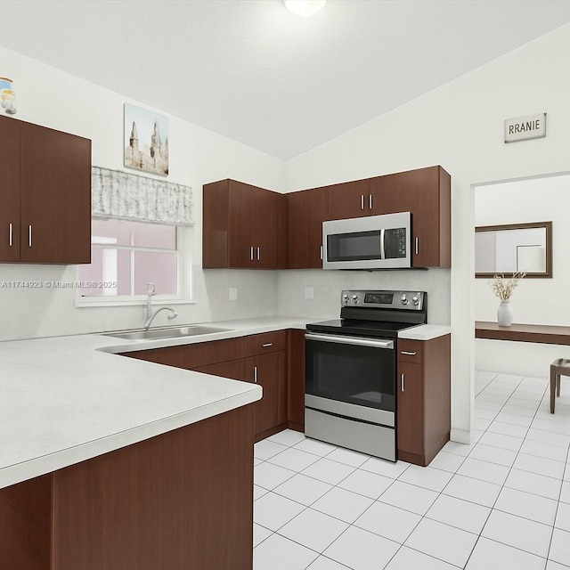 kitchen featuring light tile patterned floors, stainless steel appliances, light countertops, and a sink