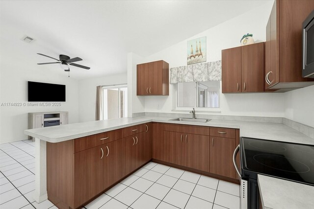 kitchen with visible vents, a sink, a peninsula, and light countertops