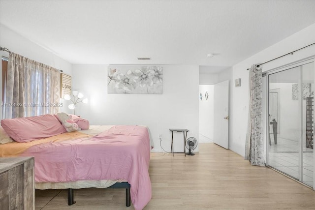 bedroom featuring visible vents and wood finished floors