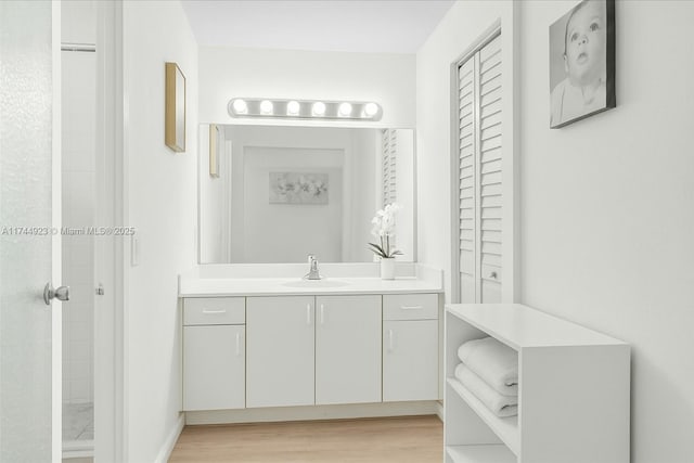full bathroom featuring wood finished floors and vanity