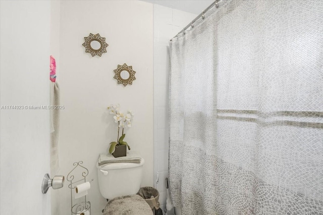 full bath with toilet and a shower with curtain