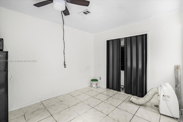 unfurnished bedroom featuring tile patterned flooring, a ceiling fan, and visible vents