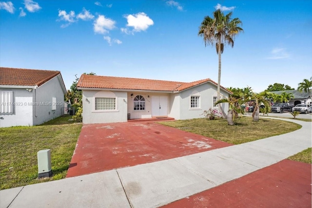 single story home with a front lawn, driveway, stucco siding, and a tiled roof