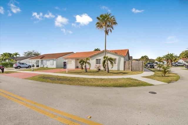 view of front of house featuring stucco siding, fence, driveway, and a residential view
