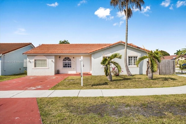 single story home featuring stucco siding, concrete driveway, a tiled roof, and a front lawn