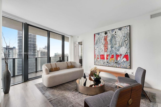 living room with a wall of windows and light wood-type flooring