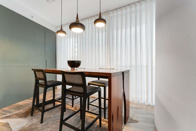 bar featuring wood-type flooring and decorative light fixtures
