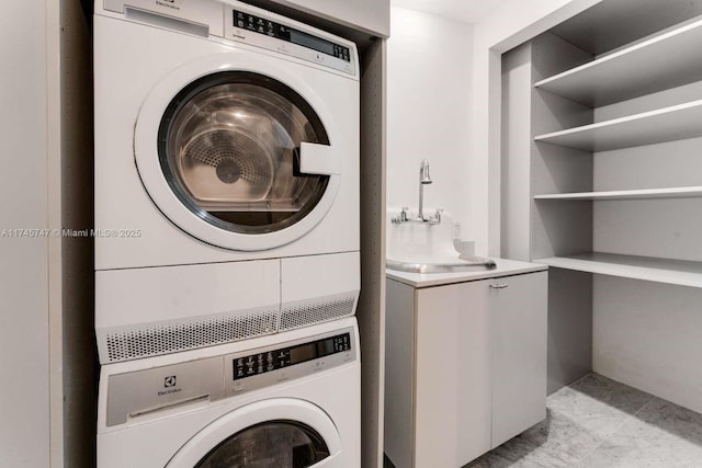 clothes washing area with stacked washing maching and dryer