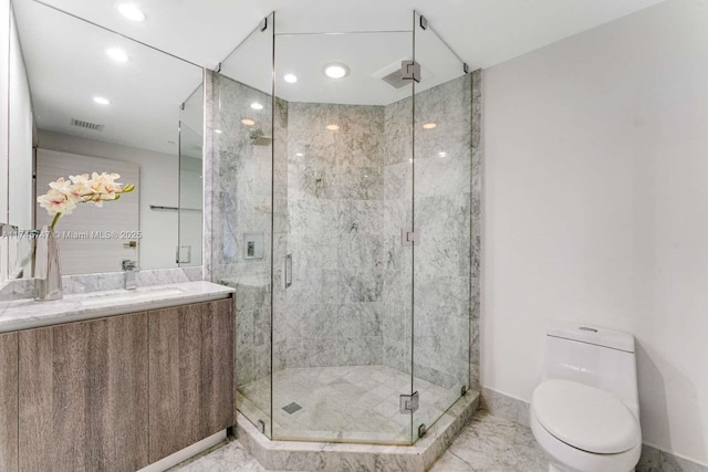 bathroom featuring an enclosed shower, vanity, and toilet