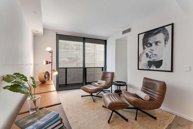sitting room featuring hardwood / wood-style flooring and a wall of windows