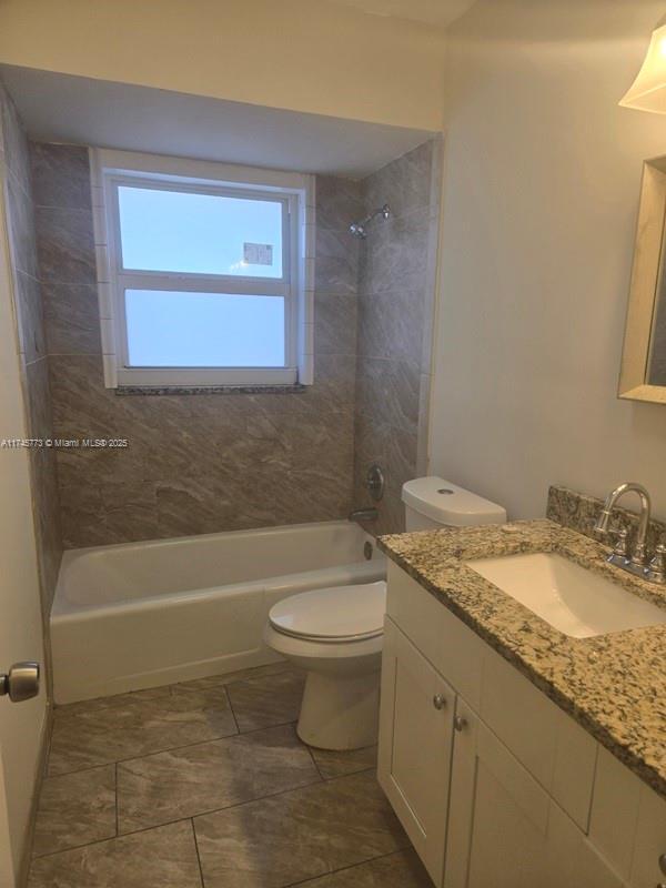 full bathroom with vanity, toilet, and tiled shower / bath combo