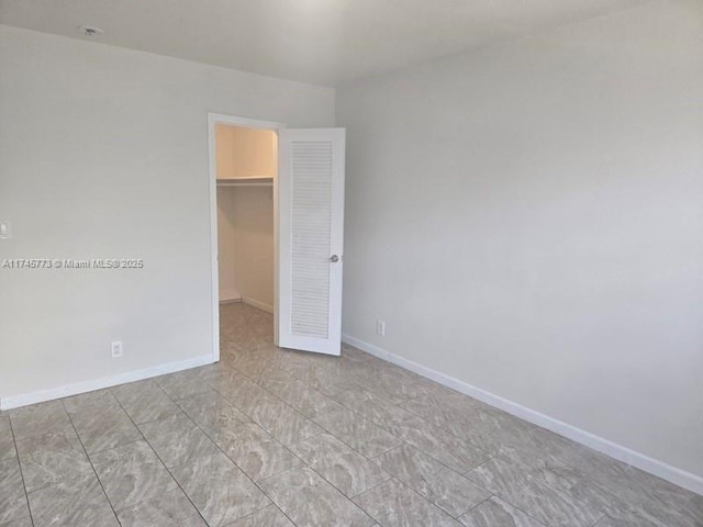 unfurnished bedroom featuring a walk in closet and a closet