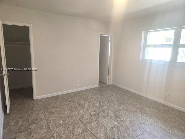 unfurnished bedroom with a spacious closet and a closet