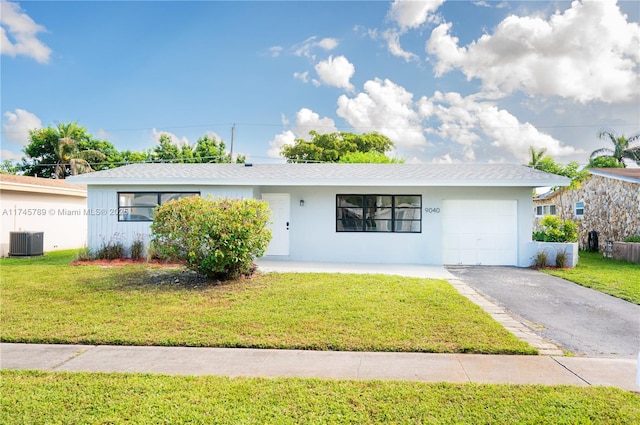 ranch-style house with a front yard, an attached garage, and central air condition unit