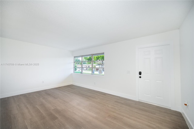 unfurnished room featuring baseboards and light wood finished floors